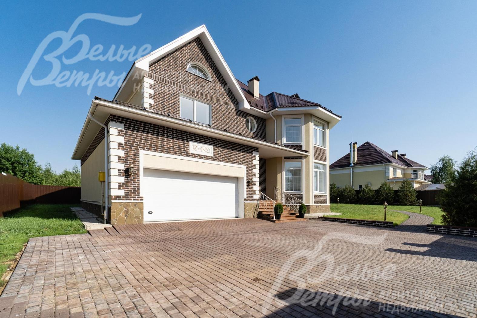 Облицовка цоколя - натуральный камень, фасады - декоративная плитка "под кирпич" (White Hills) и декоративная штукатурка с добавлением каучука