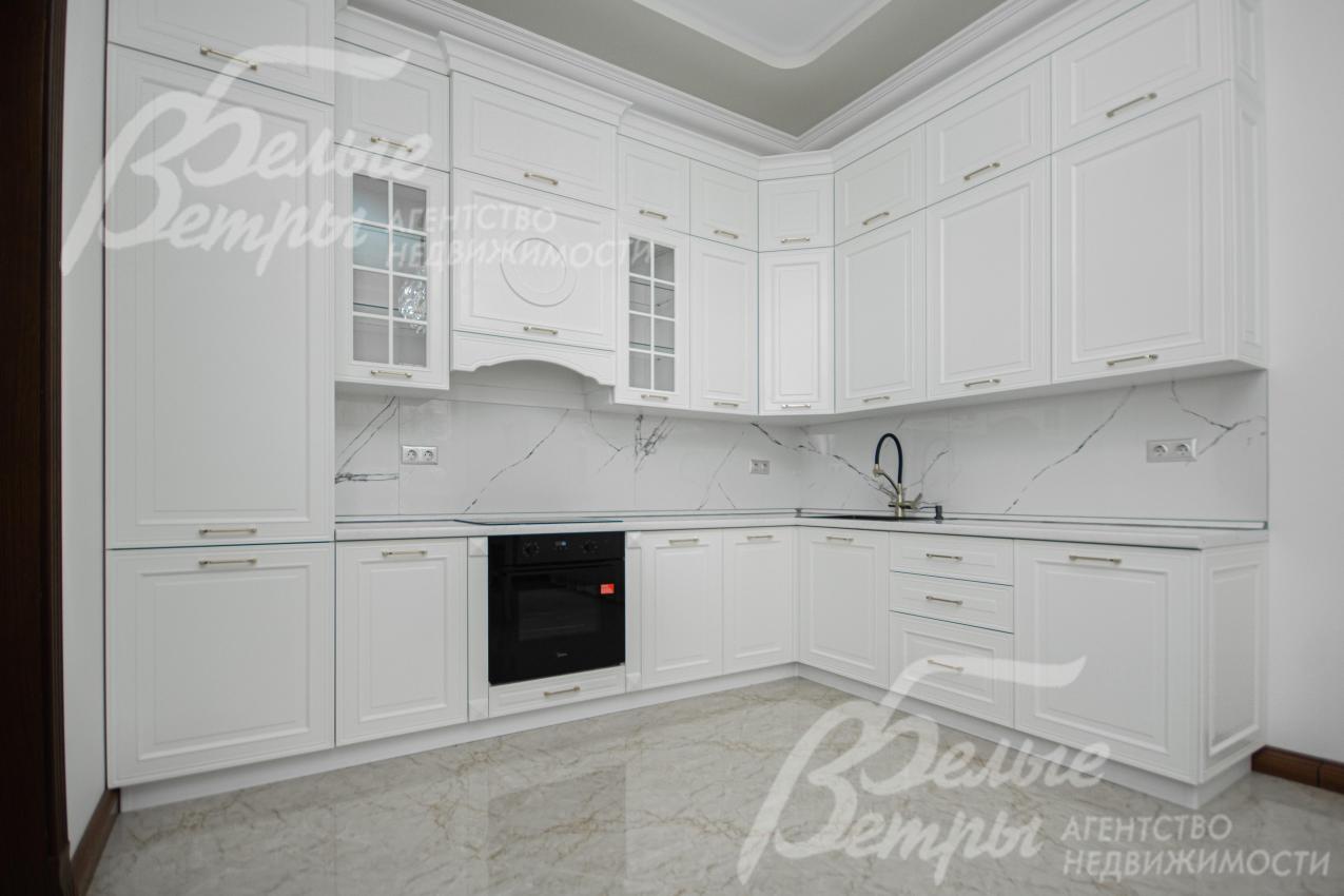 Кухонный гарнитур белого цвета со встроенной техникой