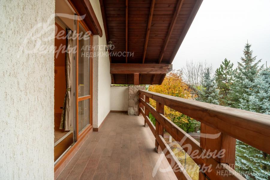 Открытая лоджия с отделкой из дерева создаёт уютное пространство для отдыха, где можно наслаждаться свежим воздухом и окружающей природой 