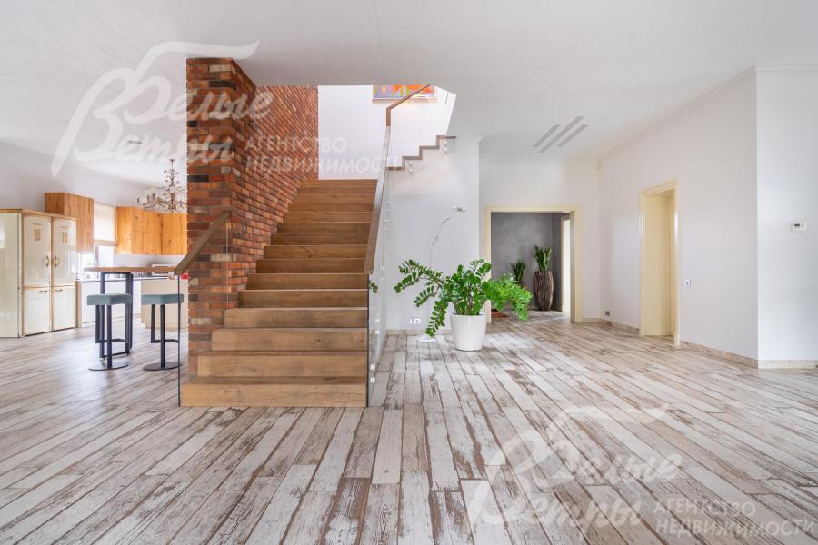 На второй этаж ведёт широкая лестница со ступенями, отделанными инженерной доской FINEX (дуб), стеклянным ограждением и поручнями FINEX