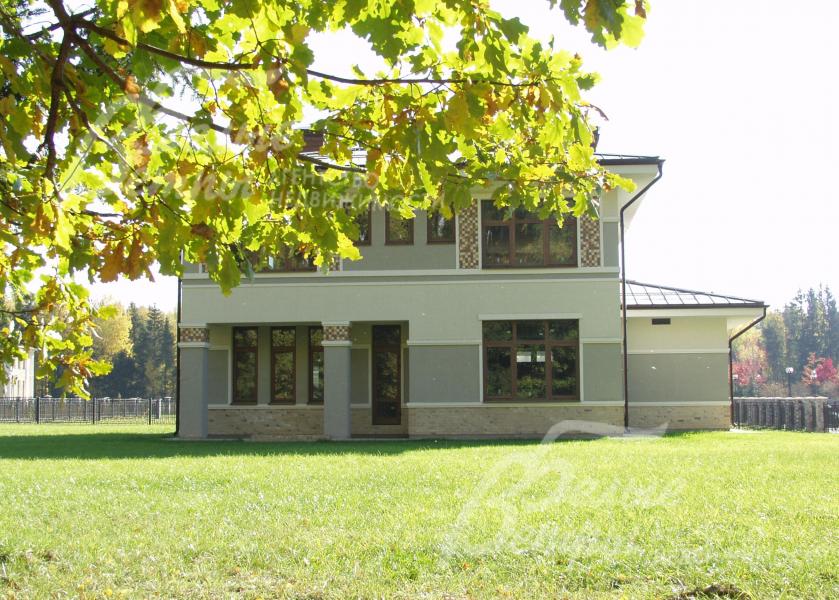 Участок около леса, с множеством лесных деревьев и кустарников по одной стороне