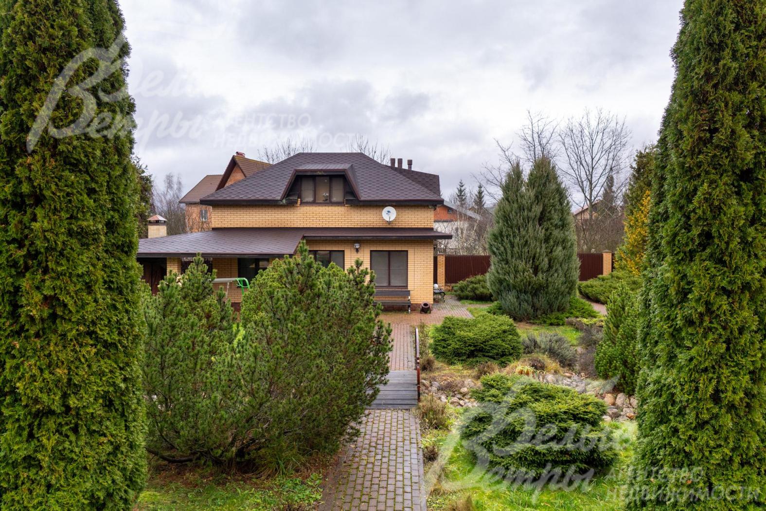 Вид на гостевой дом. По трём сторонам участок огорожен металлопрофилем на кирпичных столбах