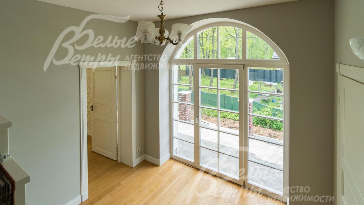 Роскошное арочное окно от пола до потолка с выходом на балкон второго этажа (над крыльцом - по английской традиции)