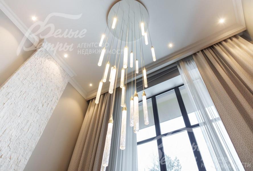 Авторская люстра в гостиной диаметром 120 см и высотой более 4м. Выполнена так чтобы она не загораживала вид на лес с обоих этажей