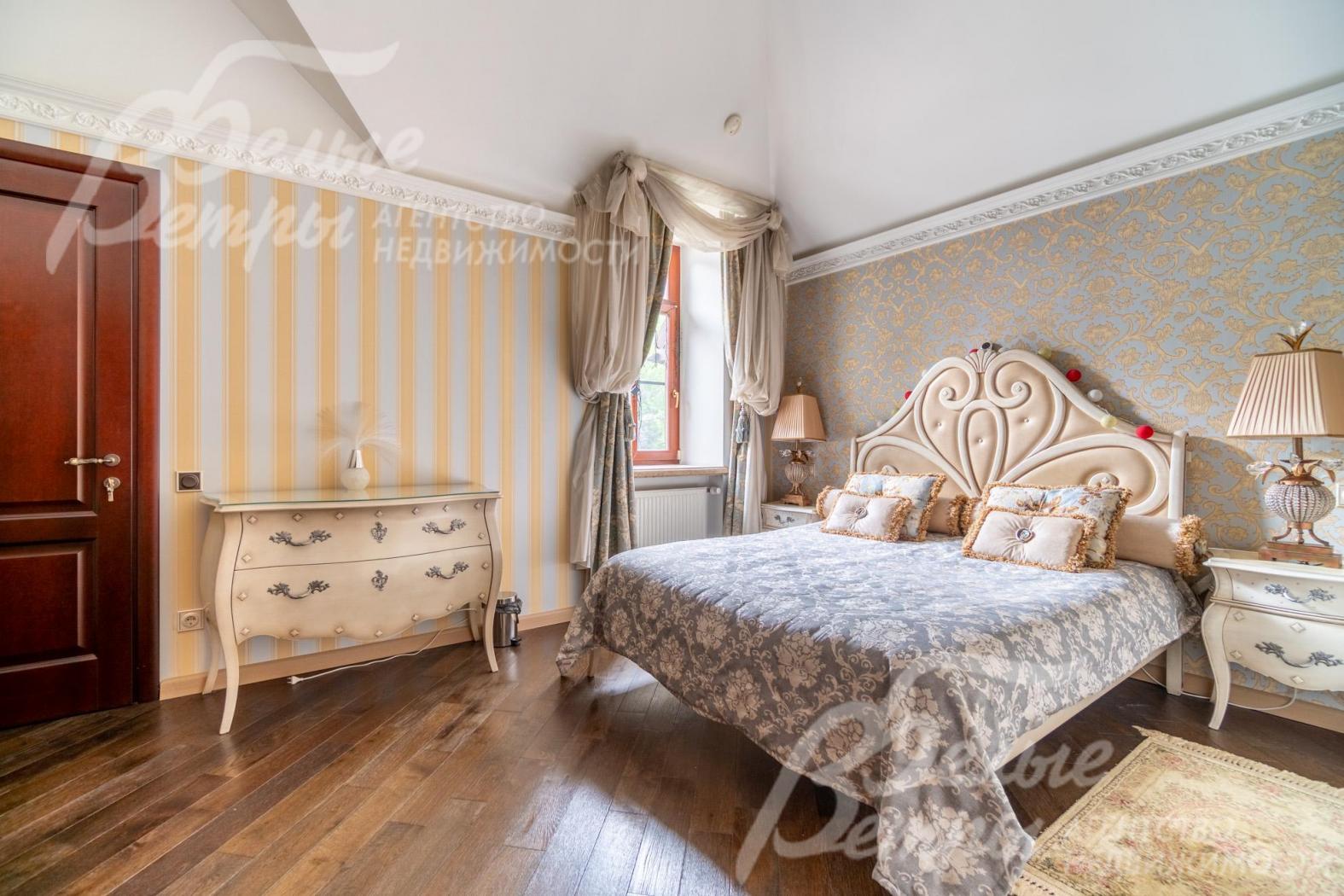 Одна из спален на втором этаже, оформленная в золотисто-голубых тонах