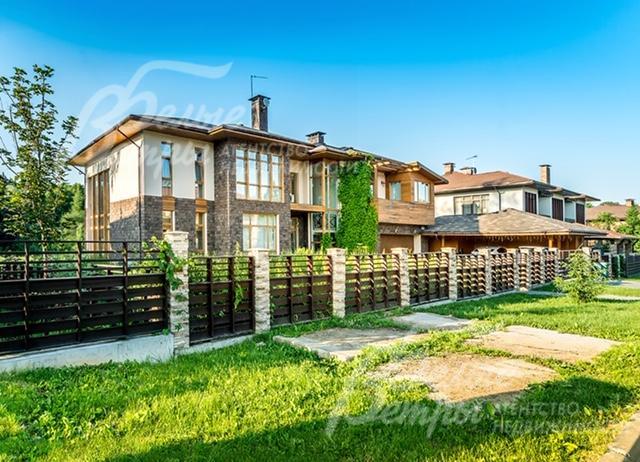 Участок огорожен деревянным забором на кирпичных столбах