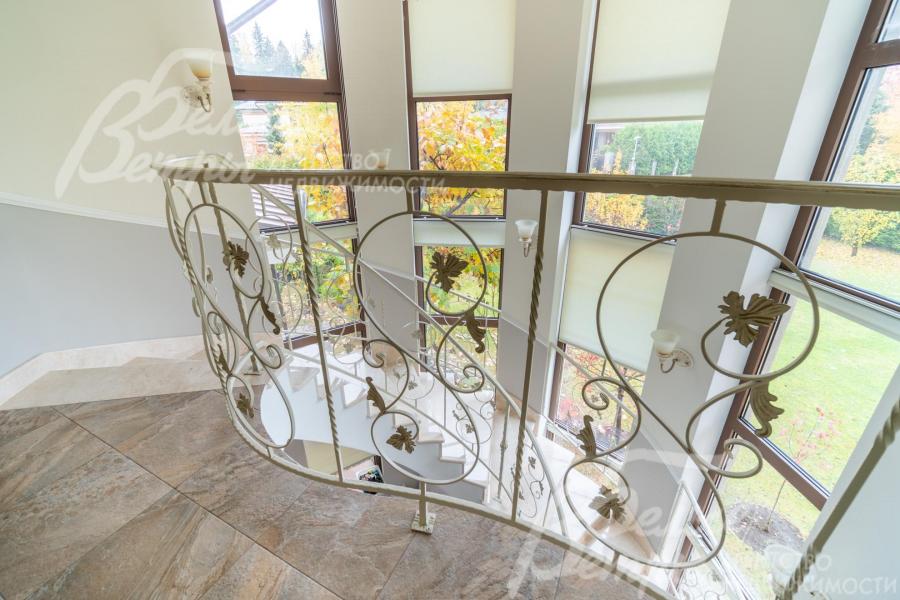 Радиусная лестница - со ступенями и подступенками из итальянского мрамора и перилами художественной ковки