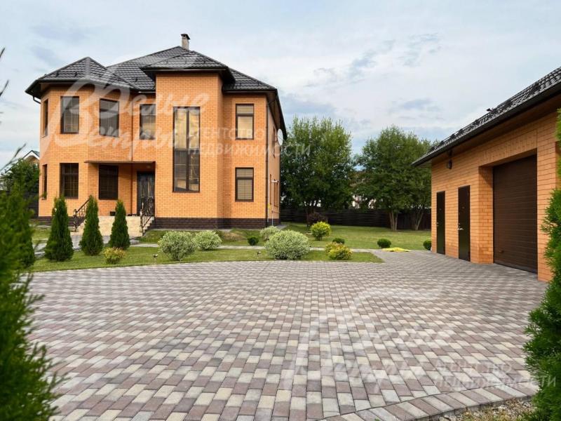 Кирпичный дом со зданием гаража на благоустроенном участке 18 соток.
