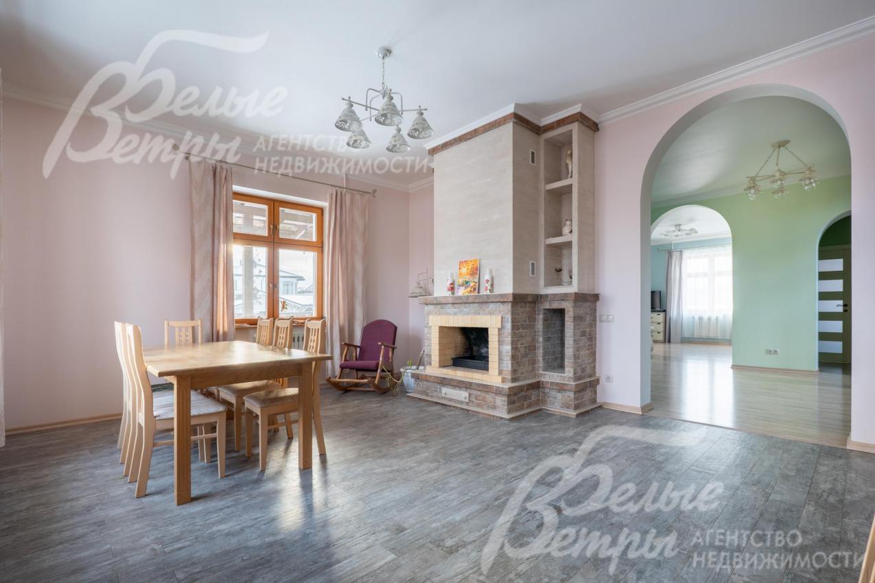 Зона кухни-столовой. Столовую украшает дровяной камин, рядом - кресло-качалка