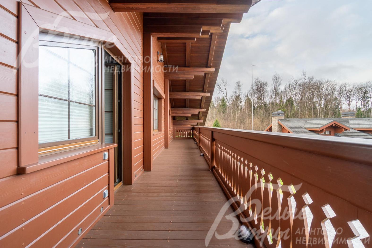 С просторной террасы при спальне с изящным резным ограждением и массивными балками под крышей открывается живописный вид на окружающую местность