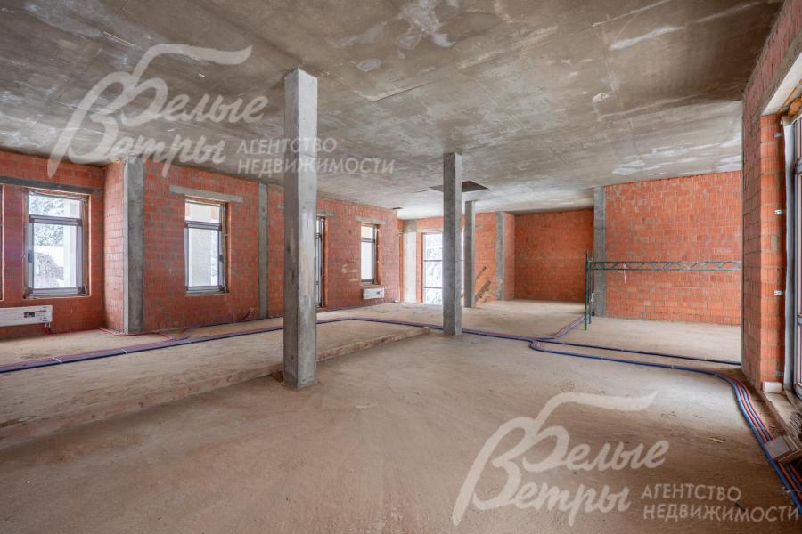 Зона кухни-столовой. Внутри дома - просторные жилые помещения, монолитные стены отделаны кирпичом