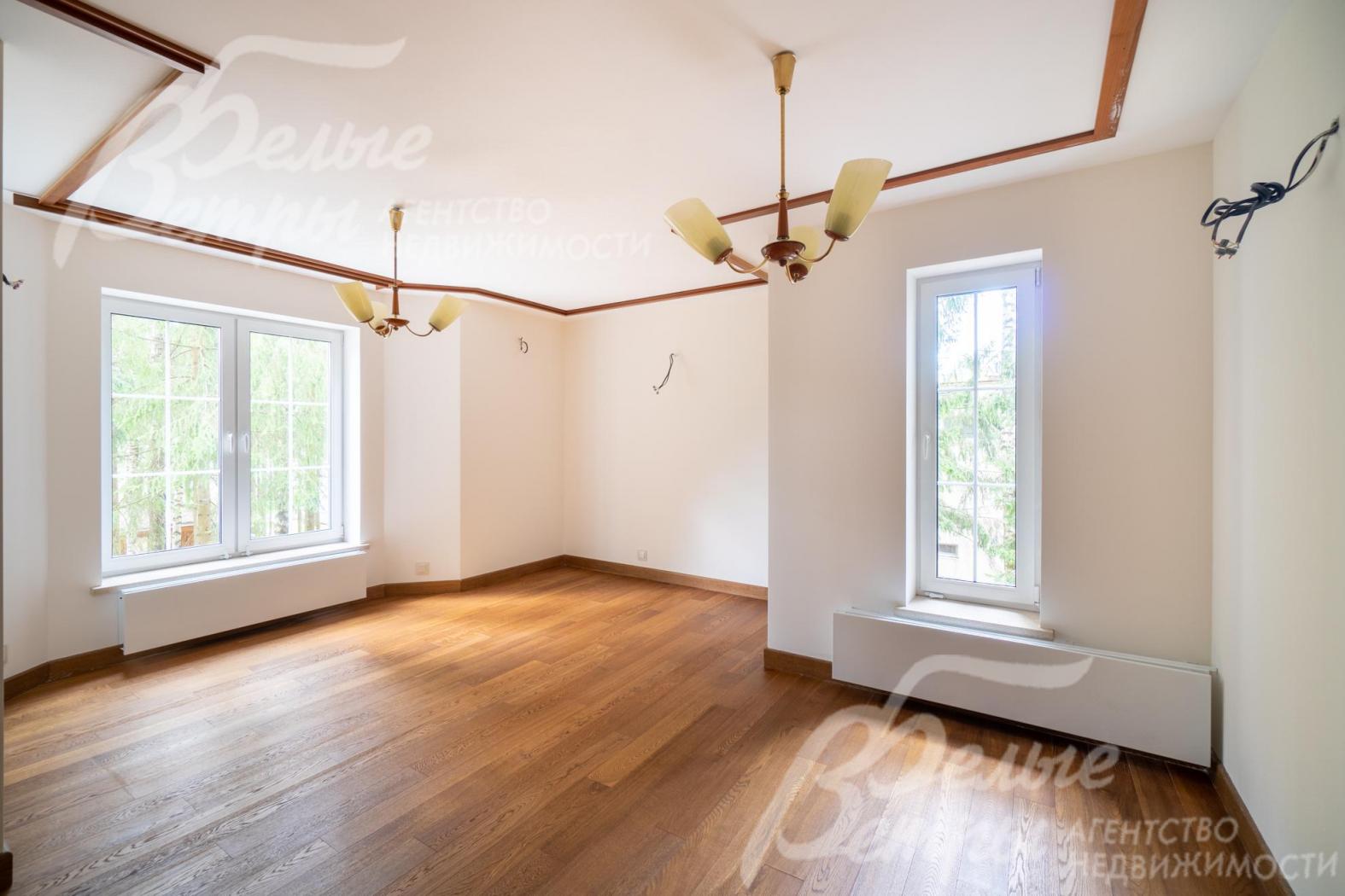 Светлая гостиная флигеля украшена деревянными балками