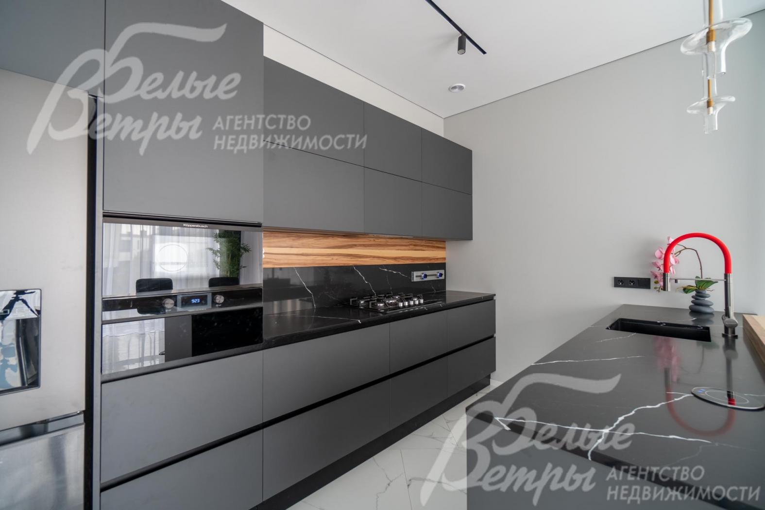 Кухня с каменной столешницей, со встроенными индукционной плитой, холодильником и другой бытовой техникой