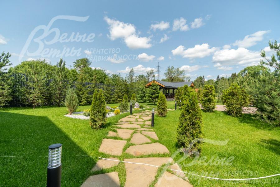 Дорожки на участке вымощены камнем, установлено уличное освещение