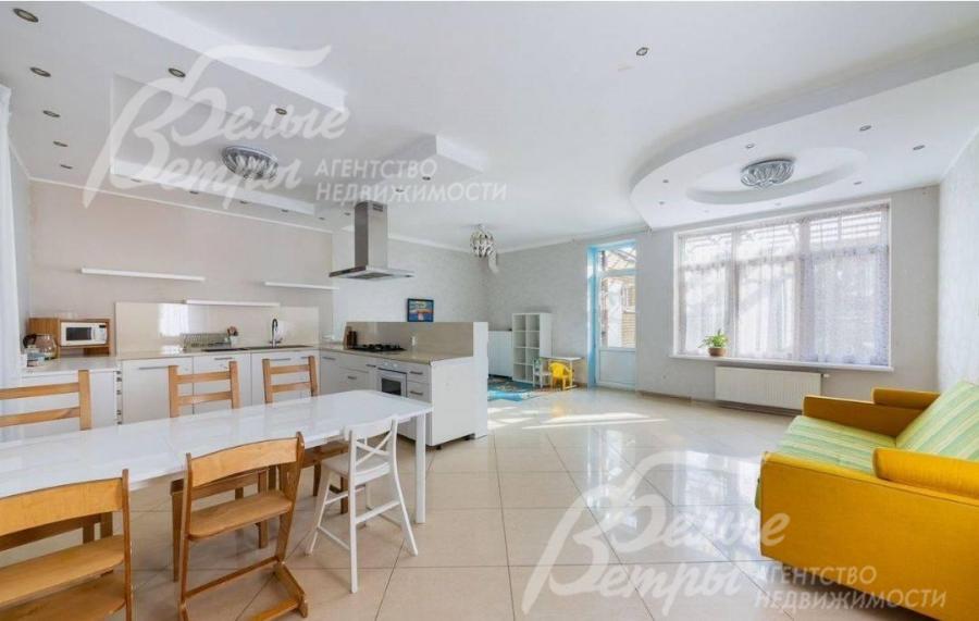 Зона объединённой кухни-столовой с большим окном и выходом на участок