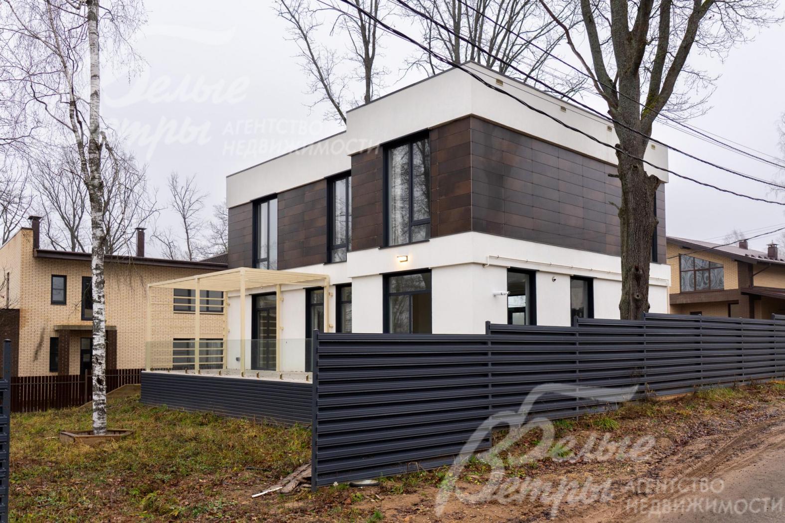 Территория огорожена металлическим забором в стиле дома