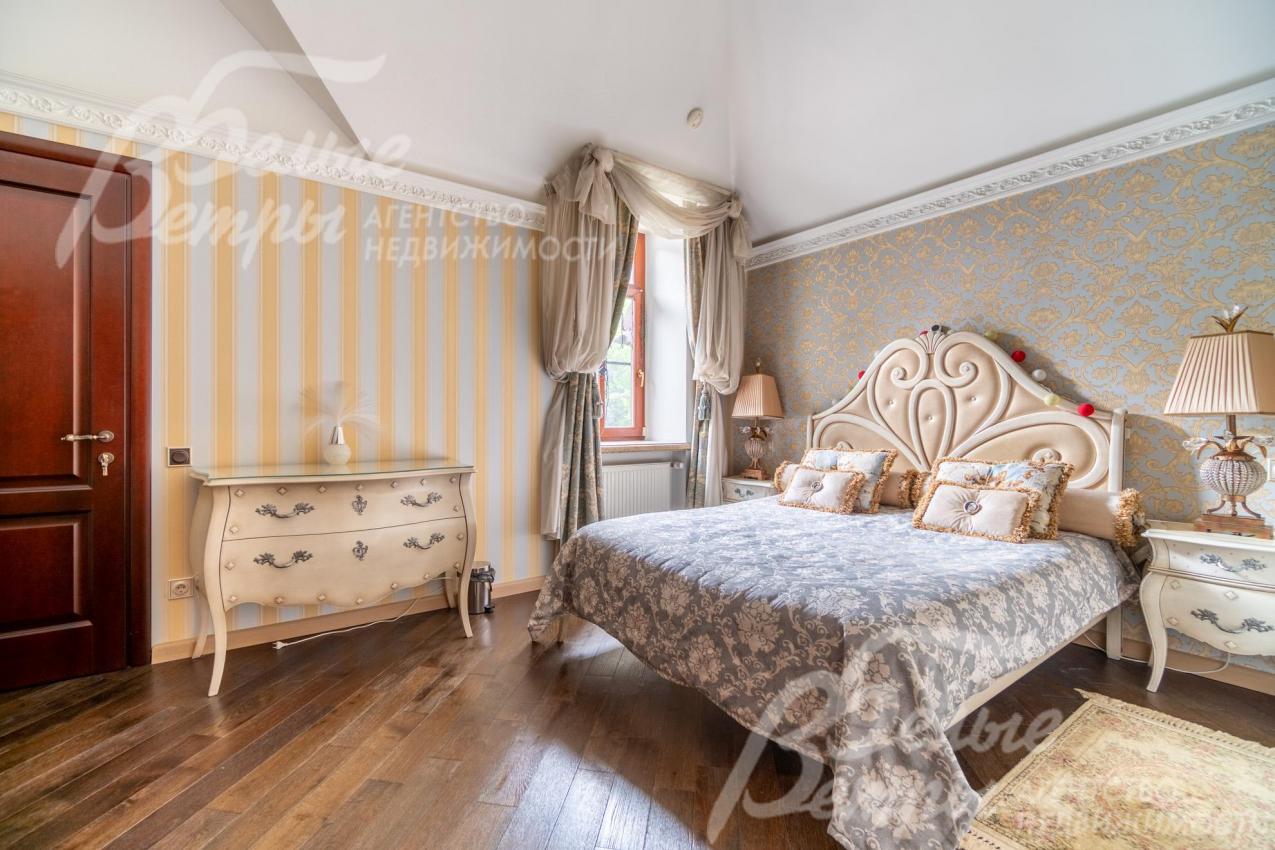 Одна из спален на втором этаже, оформленная в золотисто-голубых тонах