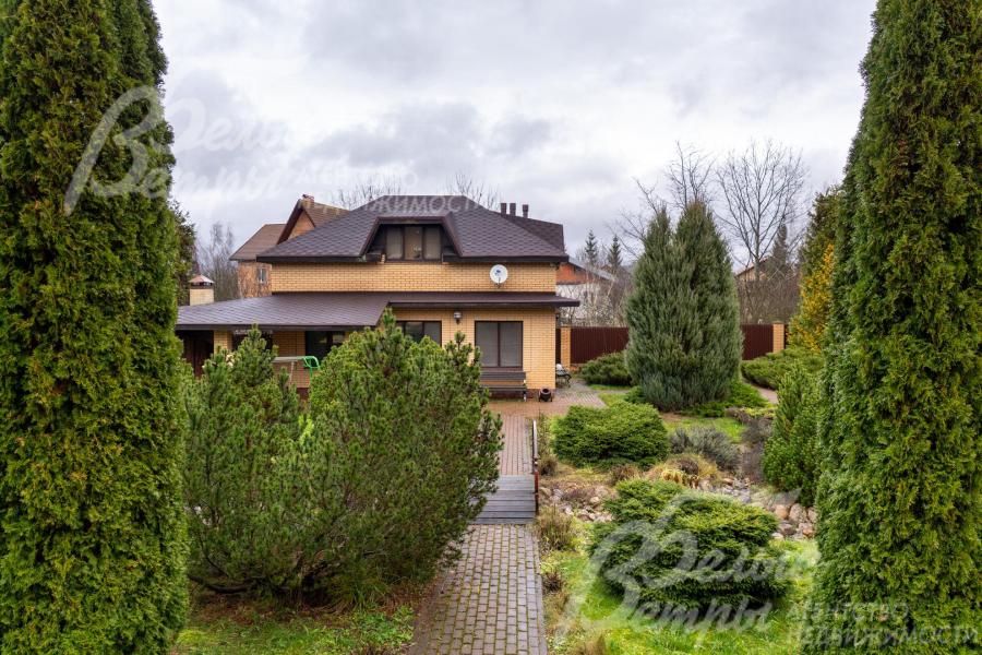 Вид на гостевой дом. По трём сторонам участок огорожен металлопрофилем на кирпичных столбах