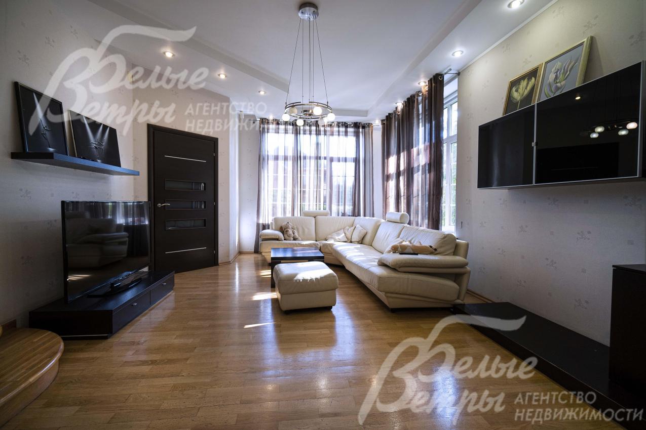 Гостиная на первом этаже дома с большой площадью остекления у диванной группы