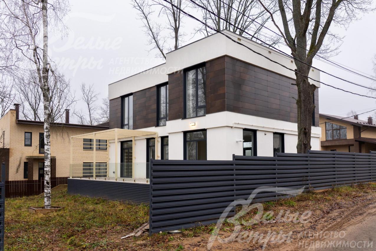 Территория огорожена металлическим забором в стиле дома