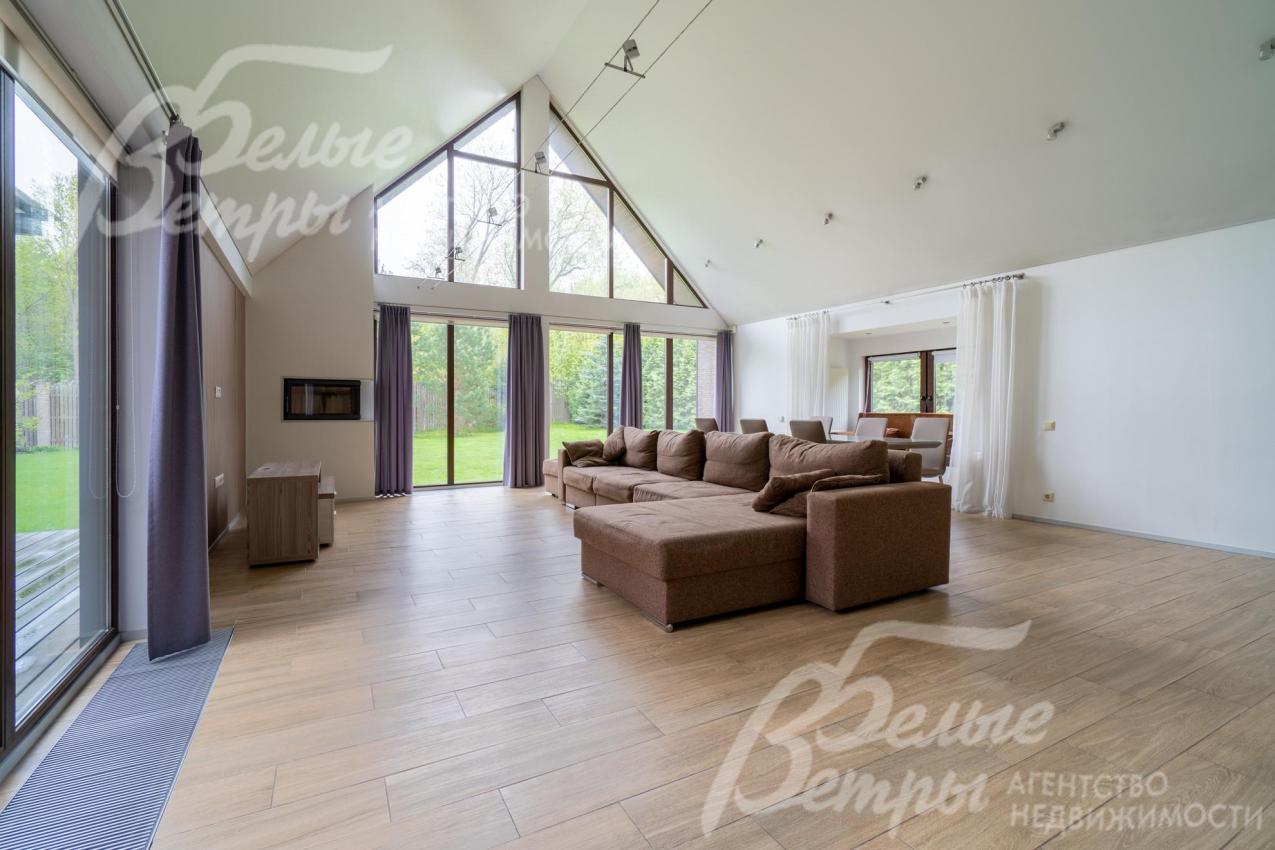 В гостиной панорамное остекление по двум стенам. Есть выход на террасу.