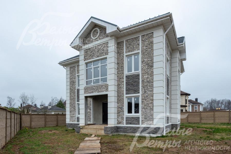 В облицовке дома сочетаются бетонная фасадная плитка, рустовка и штукатурка "короед"