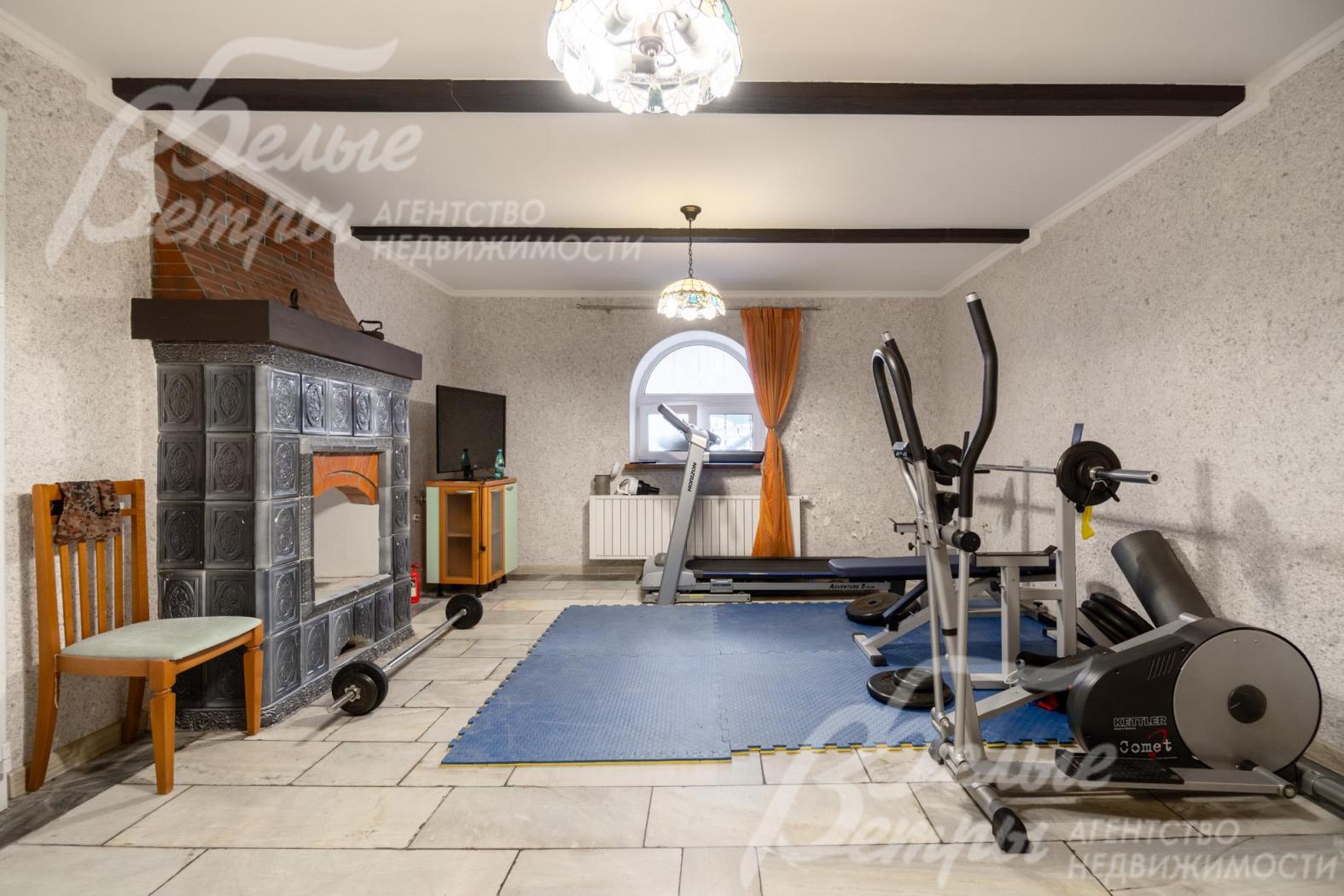 Комната на цокольном этаже со вторым камином, оборудована под спортзал 