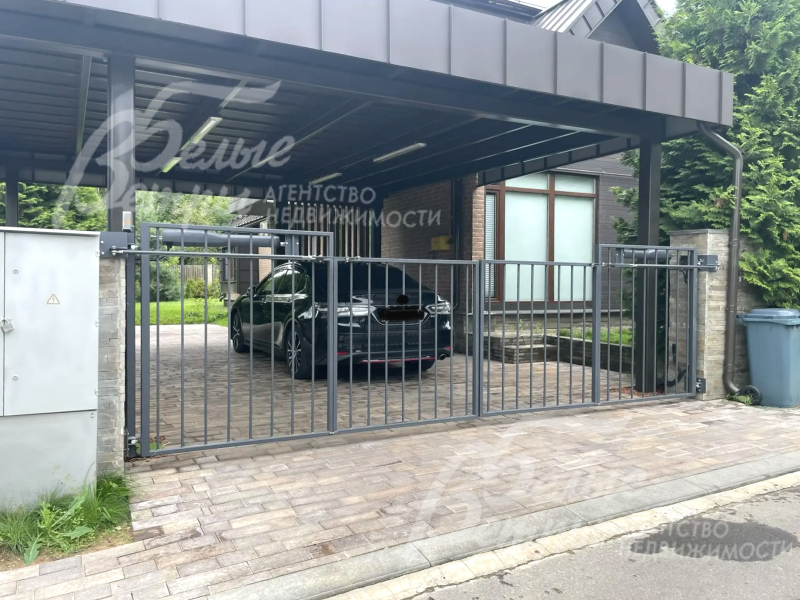 К дому примыкает навес для стоянки двух авто