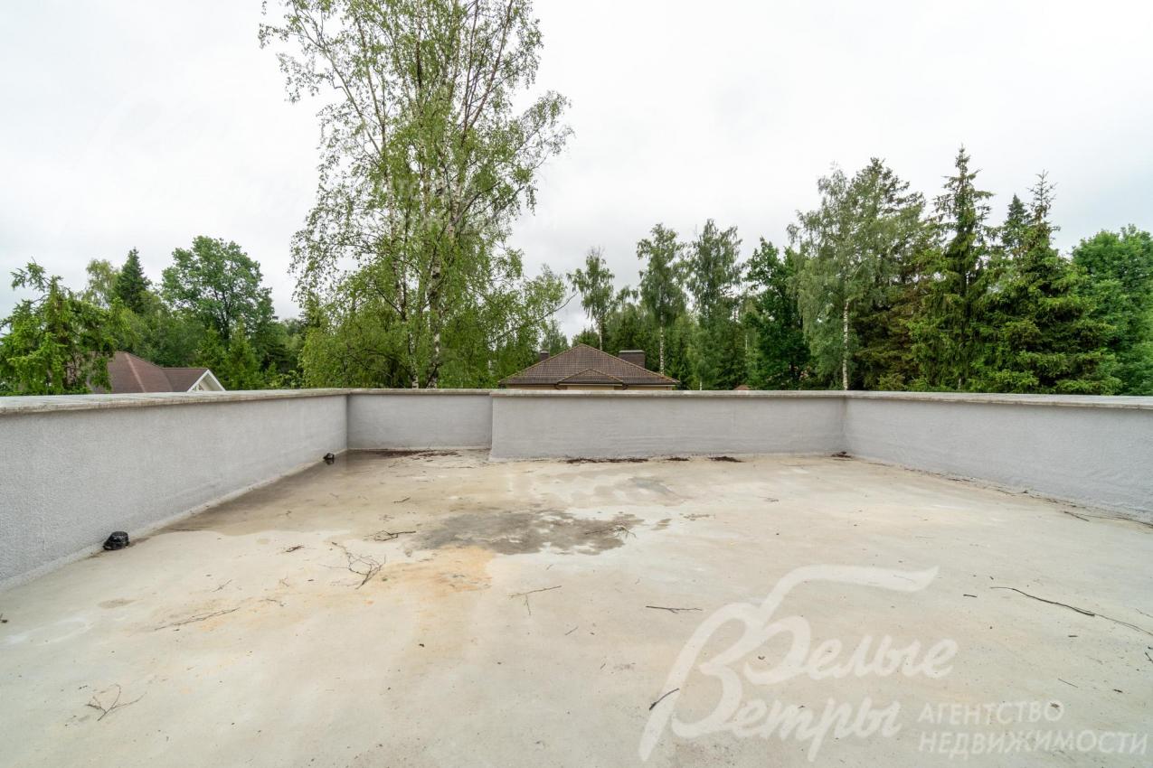 В доме - панорамная эксплуатируемая кровля с видом на посёлок и лес