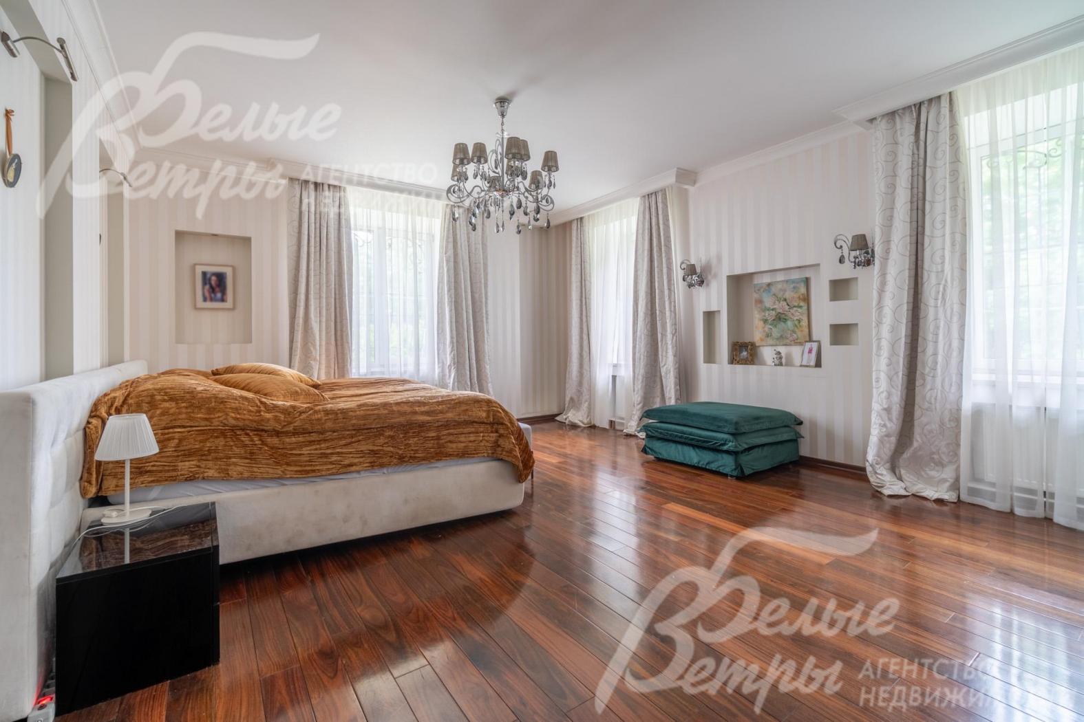 Мастер-спальня на втором этаже с большими окнами, установлен спальный гарнитур