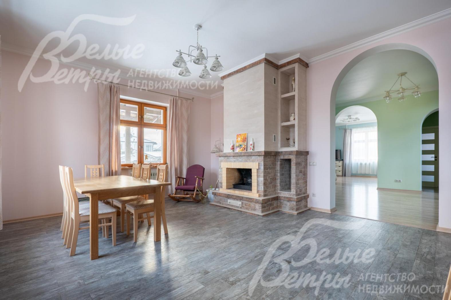 Зона кухни-столовой. Столовую украшает дровяной камин, рядом - кресло-качалка