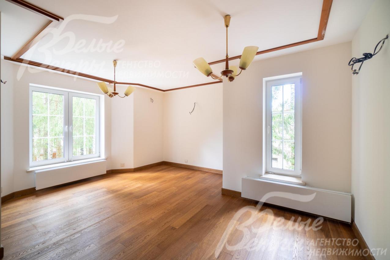 Светлая гостиная флигеля украшена деревянными балками